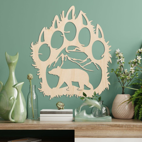 Kontrastná silueta medvedej stopy, vnútri ktorej je vidieť horský masív a postavu medveďa kráčajúceho vpred.