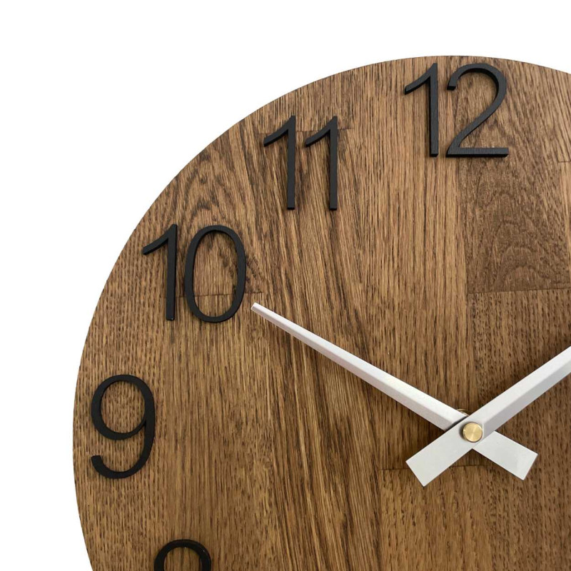 Kruhové hodiny s dekoratívnym výrezom v stredovej časti a jemnou kresbou dreva.