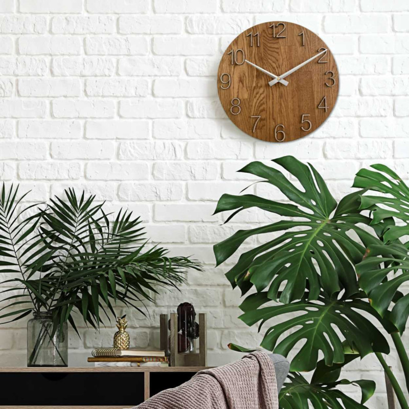 Kruhové hodiny s dekoratívnym výrezom v stredovej časti a jemnou kresbou dreva.