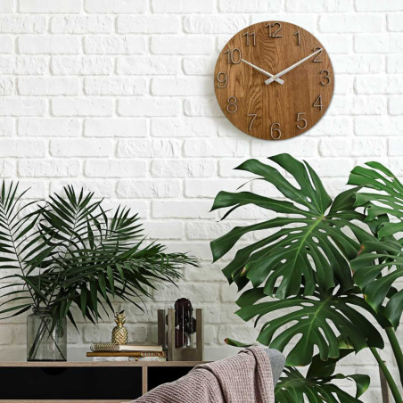 Kruhové hodiny s dekoratívnym výrezom v stredovej časti a jemnou kresbou dreva.