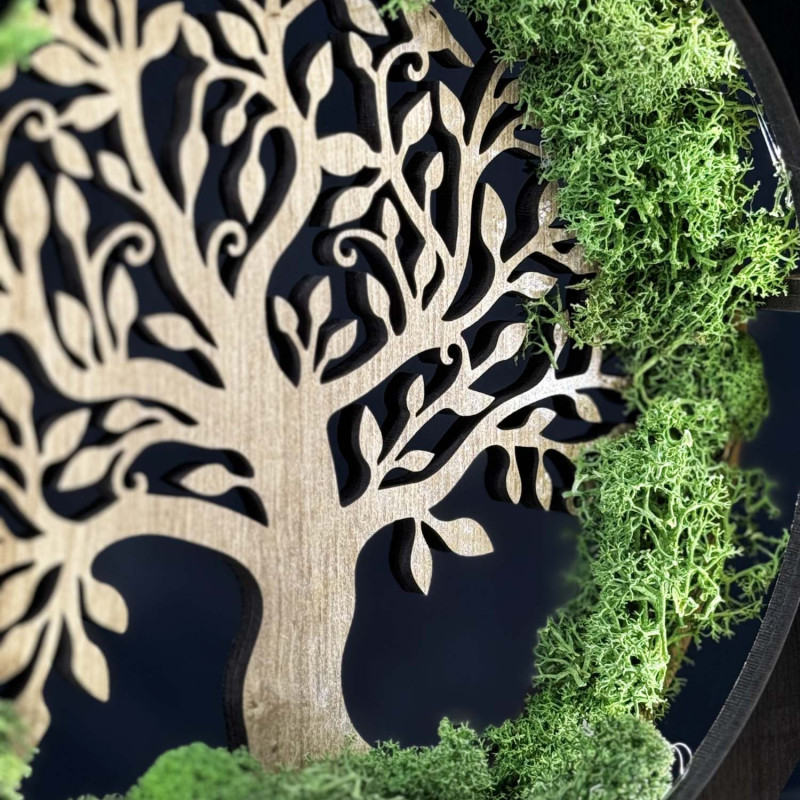 Detailný pohľad na podsvietený drevený Strom života obklopený machom.